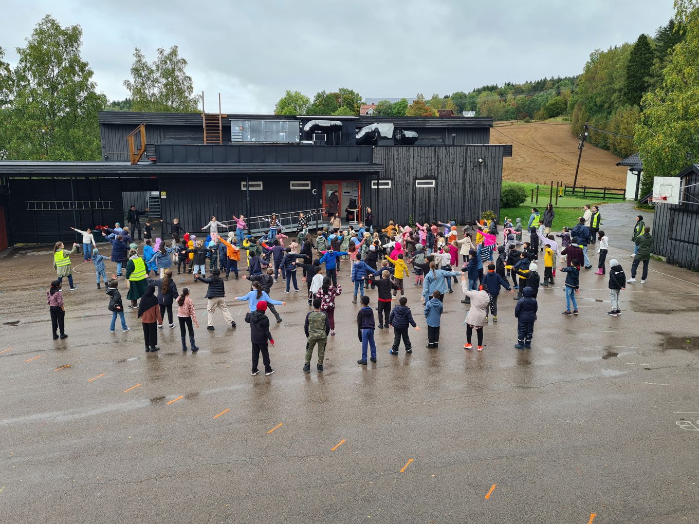 Elever og lærere danser Blime-dansen i skolegården