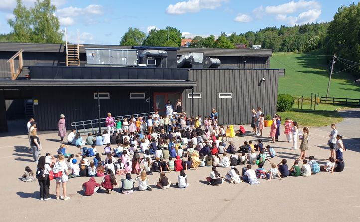 Hele skolen samlet i store skolegård.