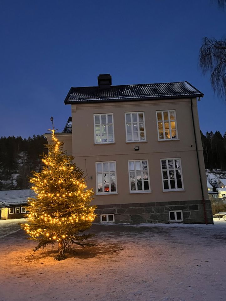 Juletre i skumring foran det gamle bygget
