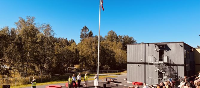 Foto: Foresatte og skolestartere som sitter på amfiet foran en flaggstang Foresatte og skolestartere som sitter på amfiet foran en flaggstang